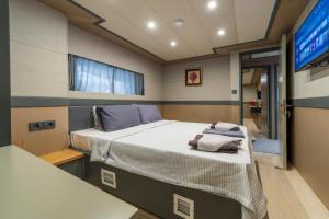 ein kleines Zimmer mit einem Bett und einem Fernseher in der Unterkunft Explorer Yacht in Fethiye