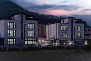 a large building with lights on in a field at Konjiam Ire Pension in Gwangju