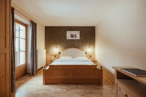 un dormitorio con una cama y una ventana en Ciasa Pedaga, en San Vigilio Di Marebbe