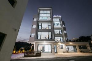 a tall building with many windows at night at Geojedo Lucas Pension Indoor BBQ in Geoje 