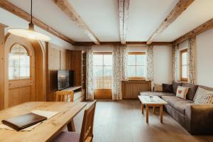 una sala de estar con un sofá y una mesa en Ciasa Pedaga, en San Vigilio Di Marebbe