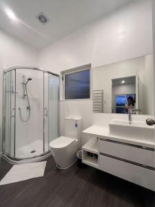 a bathroom with a shower and a toilet and a sink at U&U 2bedrooms Home in Whangaparaoa