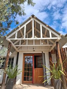 a house with a red door and a roof at Lentelus-Greeff Cottage in Oudtshoorn