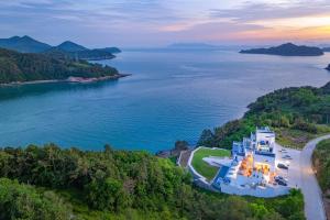 an aerial view of a large house on the shore of a lake at Yeosu 48 Hour Pool Villa in Yeosu