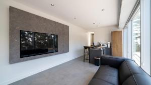 a living room with a couch and a television on a wall at Taean Oaten Pool Villa in Taean +9 photos