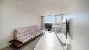 a living room with a couch and a large window at Taean Oaten Pool Villa in Taean