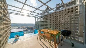 a room with a table and chairs on a balcony at Taean Oaten Pool Villa in Taean
