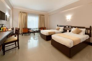 a hotel room with two beds and a kitchen at Hyson heritage calicut in Kozhikode