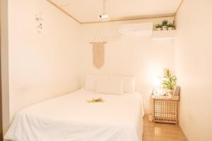 a bedroom with a white bed in a room at Aewol Handamgil Stay in Jeju