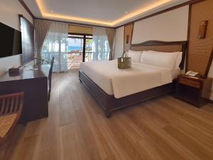 长滩岛Red Coconut Beach Hotel Boracay的一间带床和书桌的酒店房间 更多21张照片