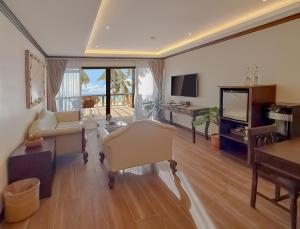 长滩岛Red Coconut Beach Hotel Boracay的客厅配有家具和平面电视。