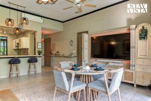 a dining room with a table and chairs and a tv at StayVista at Parkville Apartment in Alibaug