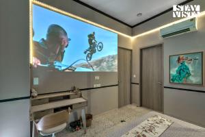 a large screen in a room with a tv at StayVista at Parkville Apartment in Alibaug