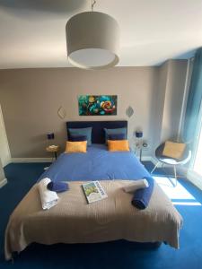 Ein Schlafzimmer mit einem großen blauen Bett und blauem Boden in der Unterkunft Le moulin de la Vernoelle in Prémilhat