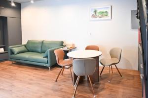 a living room with a couch and a table and chairs at Jeonju Hanok Village Stay Sun Sun in Jeonju