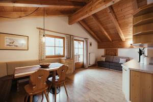 Una cocina y una sala de estar con mesa y sillas. en Ciasa Pedaga, en San Vigilio Di Marebbe