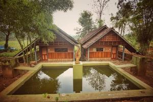 une maison avec une piscine d'eau en face de celle-ci dans l'établissement Vattakkuny Wild Orchid Resorts, à Thirunelli