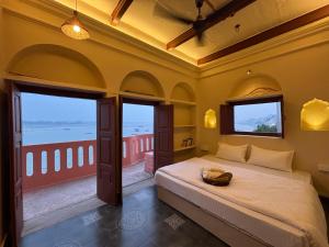 a bedroom with a bed and a view of the ocean at Vintage River Homestay in Varanasi