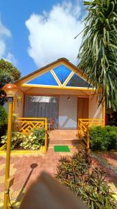 a house with a porch with a palm tree at Natures Dreamland Holiday Homes, Igatpuri in Igatpuri