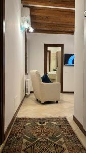 sala de estar con silla blanca y alfombra en Ca Doge Marin, en Venecia