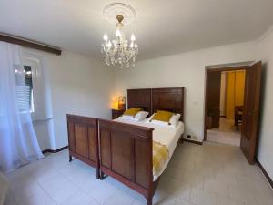 a bedroom with a large bed and a chandelier at Casa Ivy in Serra Rocco