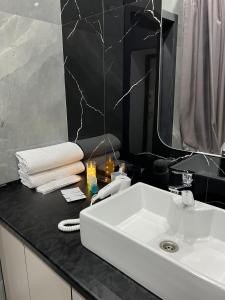 アスタナにあるСтильные апартаменты ЖК Тандауの白い洗面台と鏡のあるバスルーム