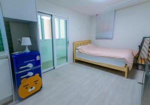1 dormitorio pequeño con 1 cama pequeña y puerta de cristal en Jeju Dongmun Residence Hotel, en Jeju