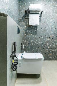a bathroom with a white toilet and a wall with dots at Misty Rock Hotels in Gundlupet +128 photos