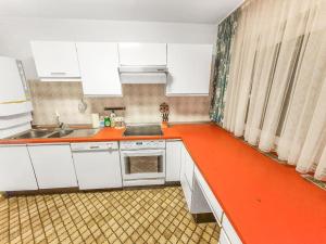 a kitchen with white cabinets and an orange counter top at Gemütliches Terrassenhaus in Degerfelden