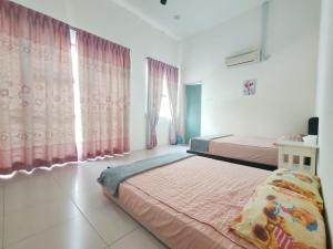 a bedroom with two beds and pink curtains at Teluk Batik 17ParadiseHome Private Pool Karaoke Snooker BBQ 15pax in Lumut +29 photos