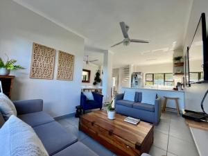 a living room with a blue couch and a coffee table at The Umdloti Lighthouse Tripelx in Umdloti