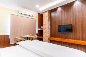 a hotel room with a bed and a tv at Misty Rock Hotels in Gundlupet