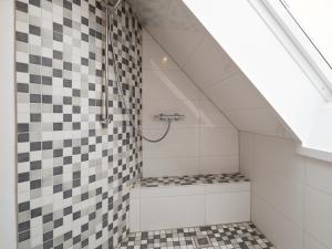a bathroom with a shower with black and white tiles at Sorgenfrei -Ruhe und Erholung in schöner Studiowohnung in Glücksburg