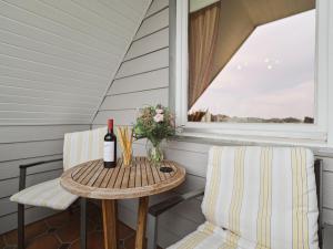 a table and chairs on a porch with a bottle of wine at Sorgenfrei -Ruhe und Erholung in schöner Studiowohnung in Glücksburg