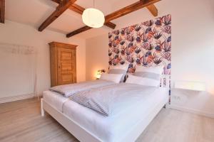 1 dormitorio con cama blanca y cabecero de flores en De lütte Boben, en Dollerup