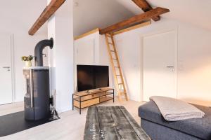 Una sala de estar con televisión y un sofá. en De lütte Boben, en Dollerup