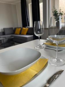 a table with a plate and two wine glasses on it at Nordic Living - 90m² im nordisch modernen Stil in Flensburg
