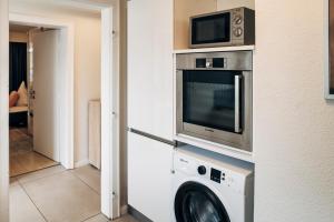 a kitchen with a microwave and a washing machine at OstseePerle in Solitüde in Flensburg +6 photos