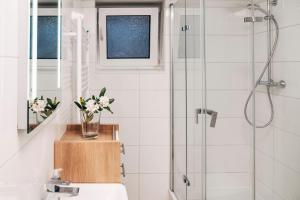 a bathroom with a shower and a vase of flowers at OstseePerle in Solitüde in Flensburg