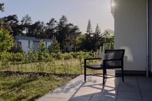 a chair sitting on the side of a building at Apartment C2 - barrierefrei mit großer Südterrasse und Naturblick im "Pine Hill Resort" in Zirchow