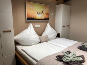 a bed with white sheets and a picture of a plane at HeiDeluxe TinyHouse in Soltau