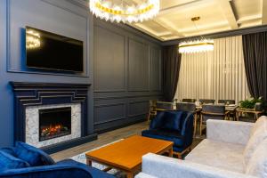 a living room with a fireplace and a table and chairs at Macara Village Resort in Quba