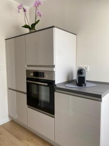 a kitchen with white cabinets and a black oven at Ferienwohnung Kleine Auszeit in Pulheim