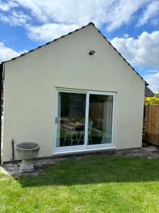 a white house with a window and a yard at Gladstone cottage in Rocester