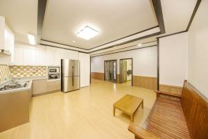 a large kitchen with a table and a refrigerator at Boryeong Daecheon Sun and Moon Pension in Boryeong