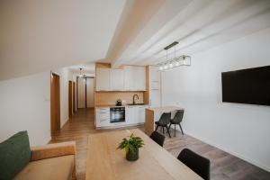 a kitchen and a living room with a table at Centrum Konferencyjno-Noclegowe in Iwkowa