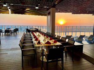 a dining room with tables and chairs and a view of the ocean at Diamond Stars Ben Tre Hotel in Ben Tre