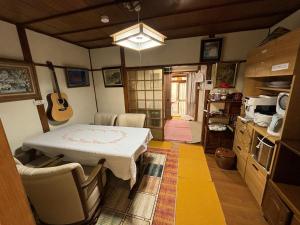 una cucina con tavolo e chitarra appesa al muro di AnNam Stay HOTARUGAIKE - - whole two story house rental a Toyonaka Altre 116 foto