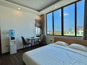 a bedroom with a large bed and a table with chairs at Pan House in Hanoi