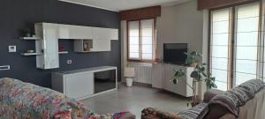 a living room with a couch and a tv at Foresteria Emilia in Grosotto +2 photos